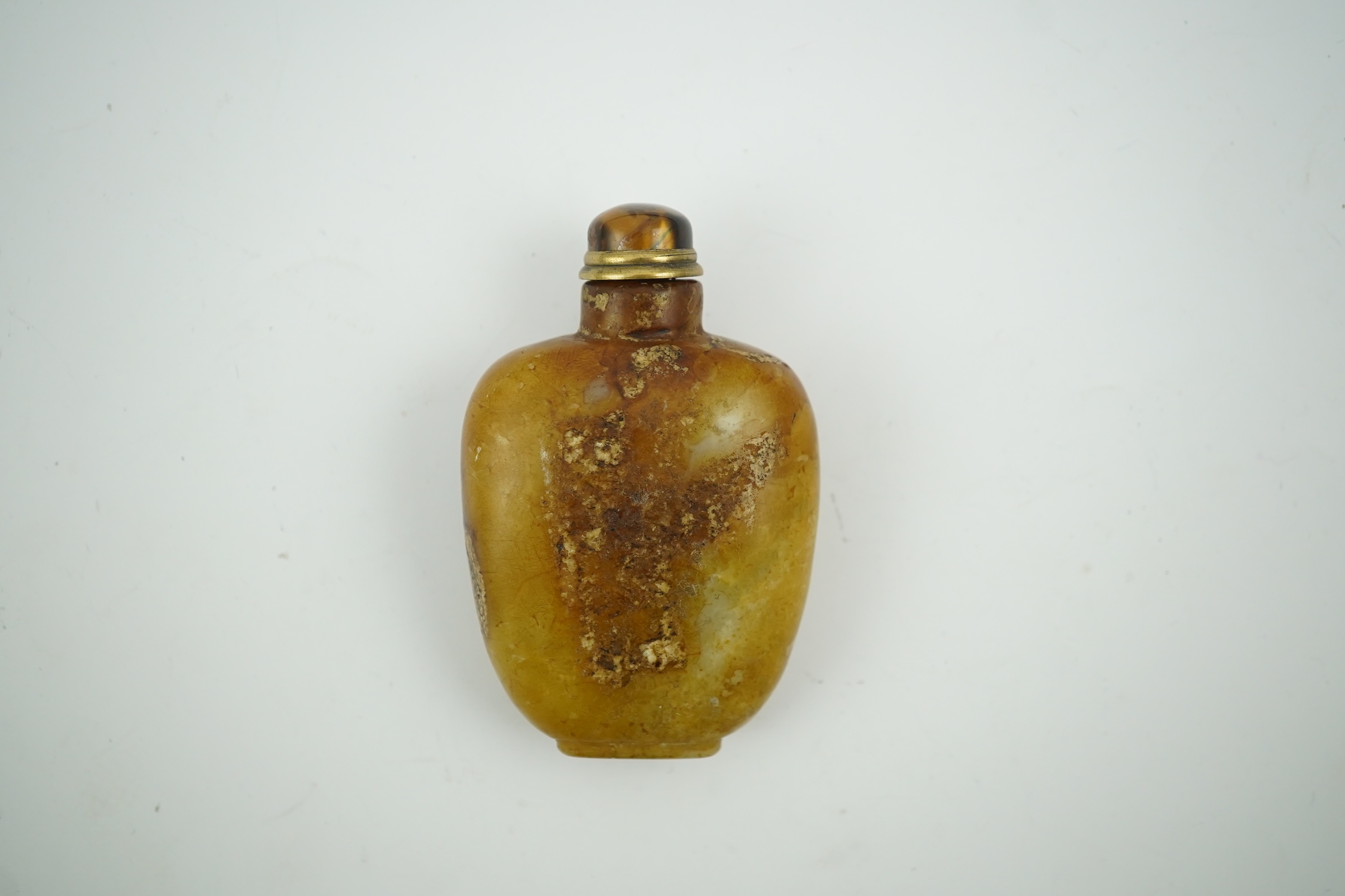 A Chinese soapstone snuff bottle with tiger's eye stopper, 8cm high. Condition - fair